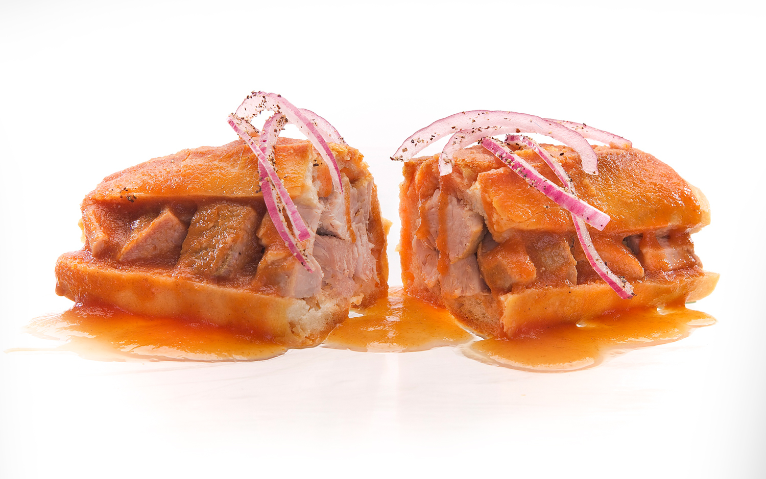 Torta ahogada — carnitas drowned in salsa with pickled red onion